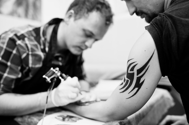 Tattoo master make tattoo for rocker man 