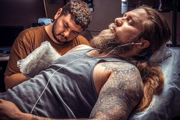 Tattoo master showing process in tattoo studio