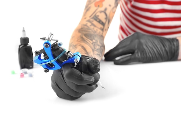 Photo tattoo master working in black medical gloves with tattoo machine close up