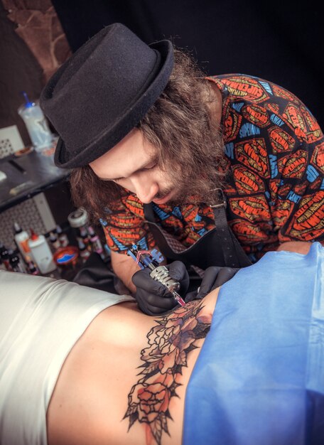 Tattoo master working on professional tattoo machine device in studio