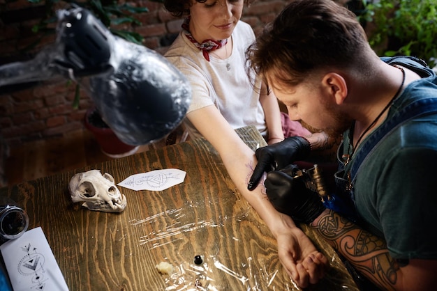 Foto maestro del tatuaggio che lavora in studio