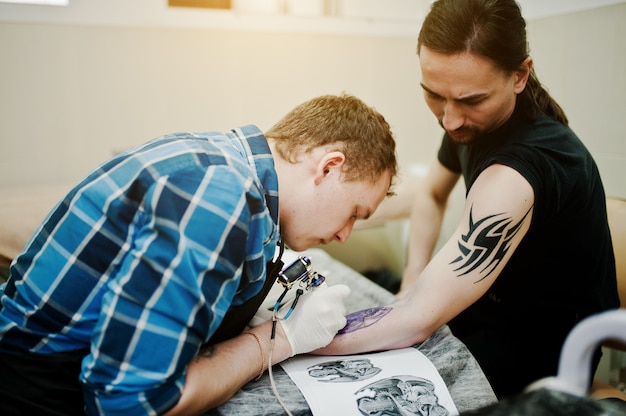 Tattoo-meester maakt tattoo voor rocker man