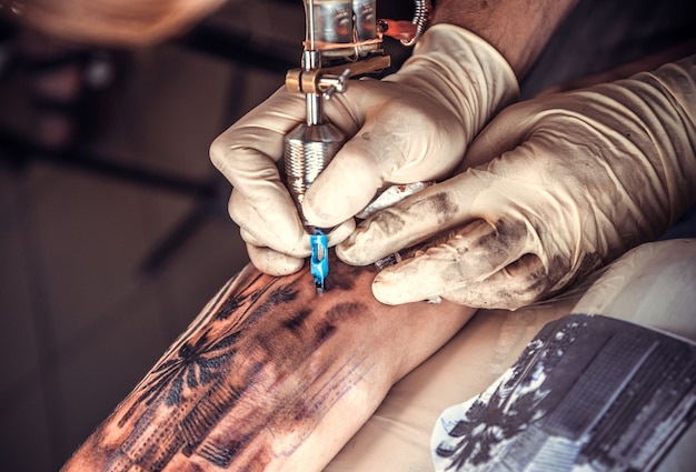 Tattoo specialist maakt tatoeage in salon.