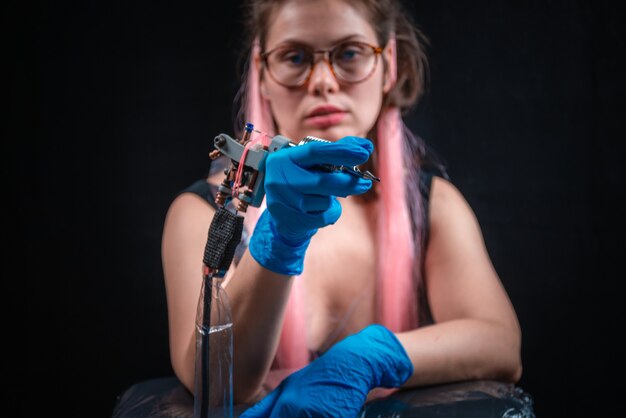 Tattoo specialist poses in a tattoo studio.