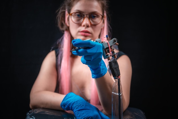 Tattoo specialist poses in a tattoo studio.