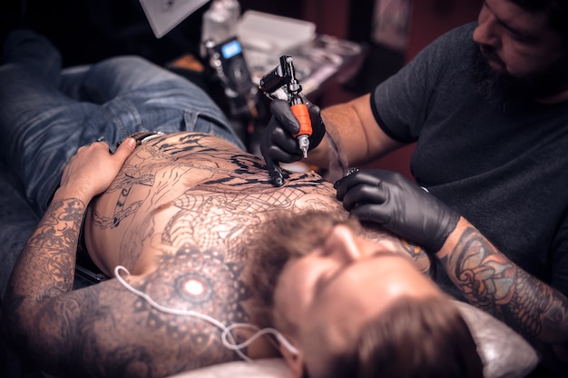 Tattoo specialist tekent een tattoo tattoo studio.