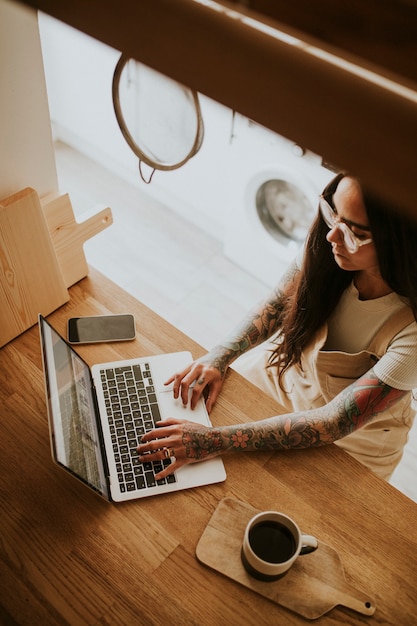 Tattooed small business owner working at home