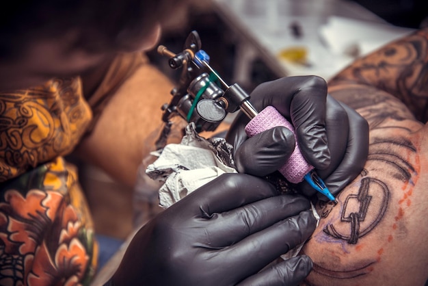 Tattooist posing in tattoo studio./Professional tattooer makes tattoo in tattoo studio.