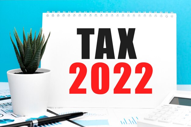 TAX 2022. Notebook, rekenmachine, grafiek. Bedrijfsconcept. Plat leggen.