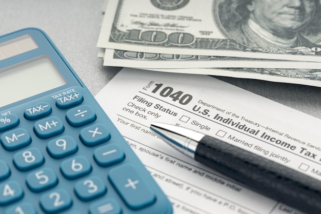 Tax concept. Tax form, calculator, money and pen on table