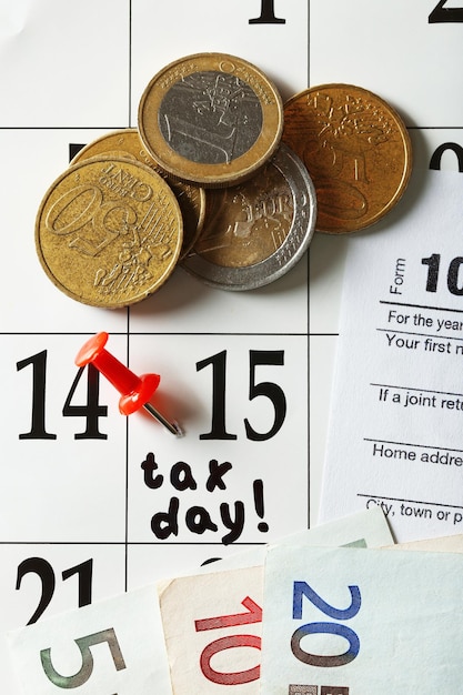 Tax day in the calendar with euro bills and coins close up