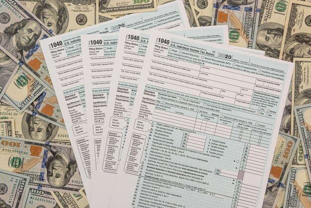 Tax Form 1040 with us 100 dollar banknotes economic accountant concept