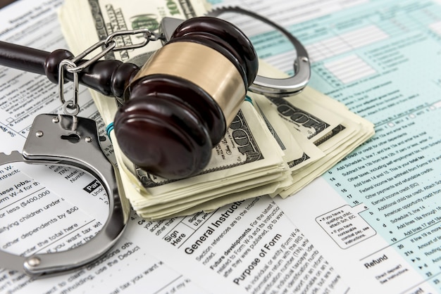 Photo tax form concept us money with handcuffs gavel lying on federal tax