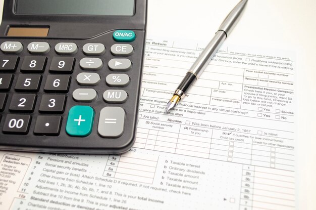 Tax form pen and calculator Tax concept