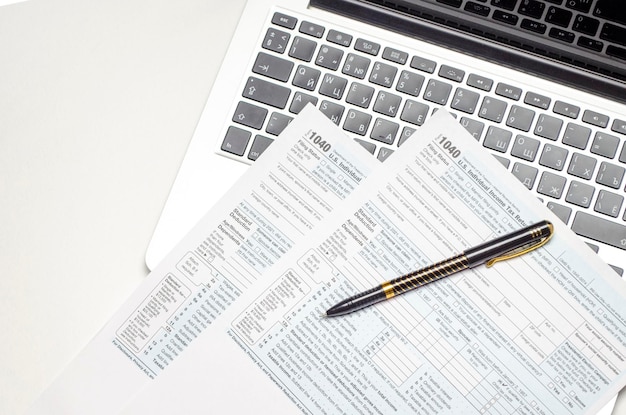 Tax form view with pen calculator and laptop