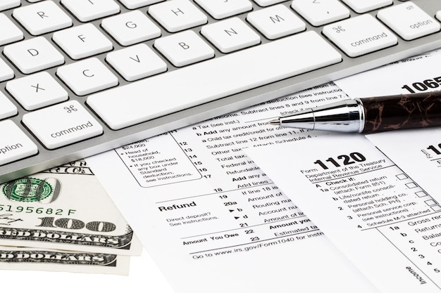 The tax forms with  money and the pen. Tax Day concept.