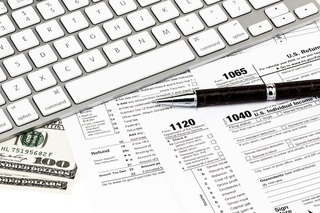 Photo the tax forms with  money and the pen. tax day concept.