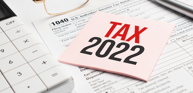 Photo tax forms with pen, calculator, glass and sticker. tax 2022