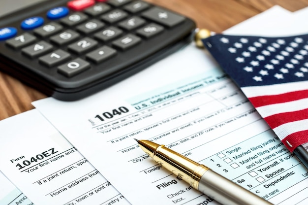 Photo tax forms with small american flag and calculator on the table business concept