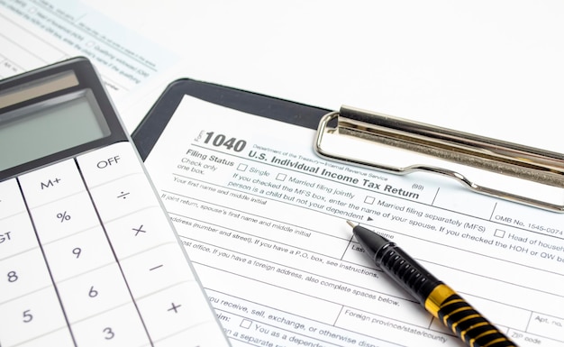 Tax Return 1040 calculator and pen Tax concept