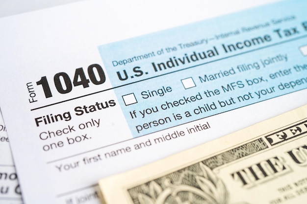 Tax Return form 1040 and dollar banknote US Individual Income