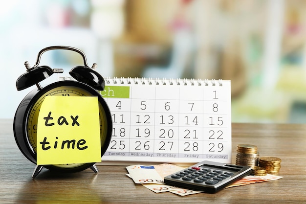 Tax time on alarm clock with euro calculator and calendar