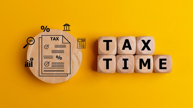 Tax time concept with text on wooden cubes on a yellow background tax payment reminder or annual taxation concept