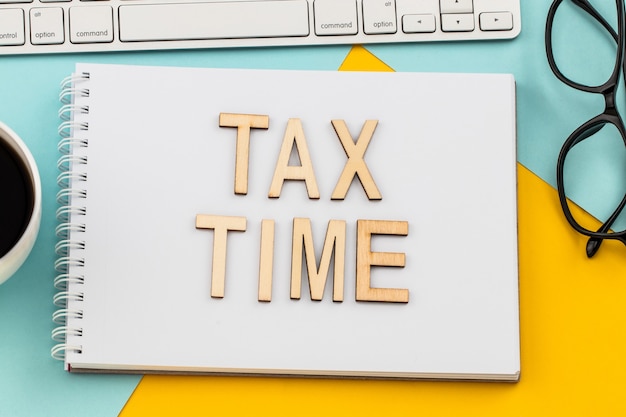 Tax Time houten letters met belastingformulier en kopje koffie.