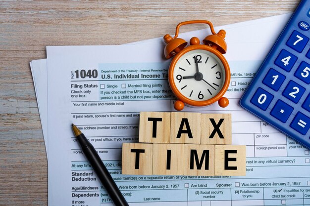 写真 税務フォーム1040米国個人所得税申告書付き木製ブロックに書かれた税務時間の言葉 事業と税金の概念