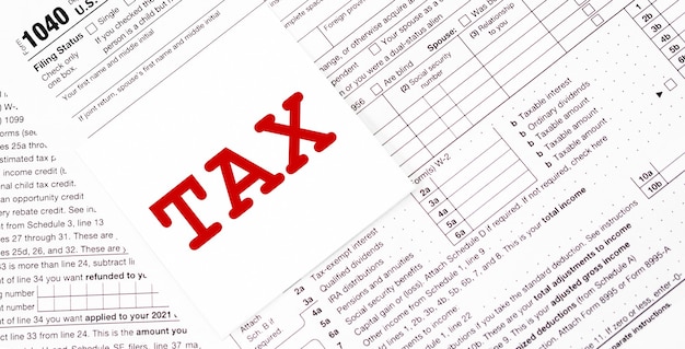 Tax written on yellow sticker note with paperclip to tax form