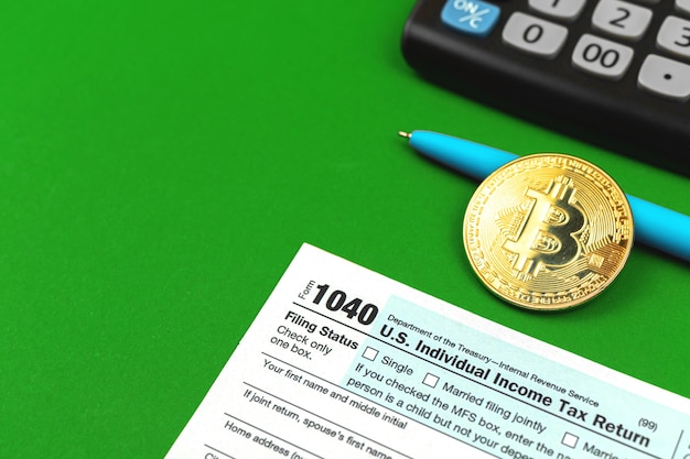 Taxes and bitcoin background, office desktop with the calculator and cryptocurrency coin
