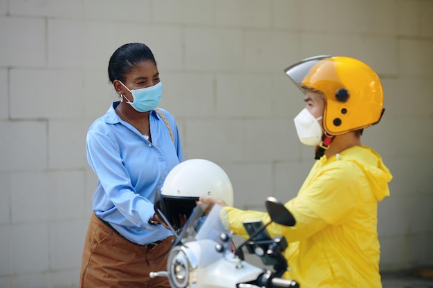 Taxi passenger putting on helmet