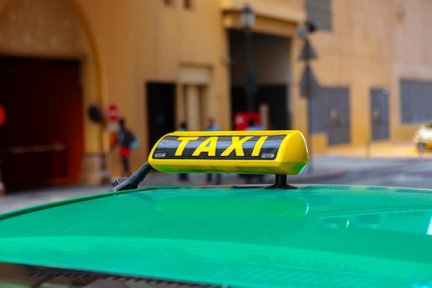 Taxi sign on the roof of a car in a street