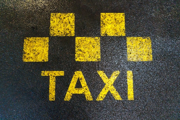 Taxi-wegmarkeringen De plaats waar taxi's en voertuigen met een vaste route stoppen Wegmarkeringen op nat asfalt