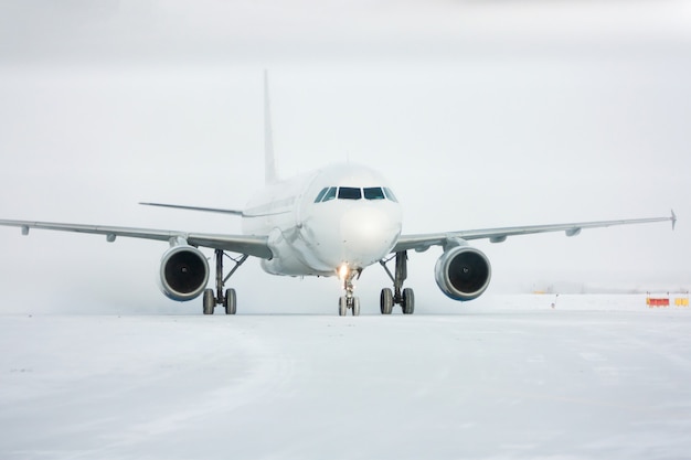 Taxiing passenger airplane in a snow blizzard