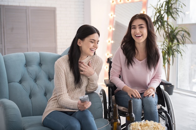 Te veel lol. Positieve zus en gehandicapte vrouw film kijken en lachen