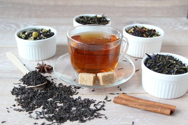 Ассортимент чая различных видов чая в миске на деревянном деревенском фоне приготовил чай в чашке