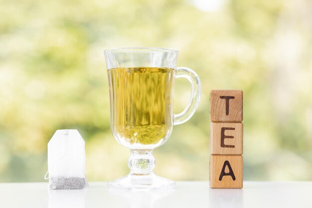 Foto bustina di tè e tazza di tè su sfondo verde estivo