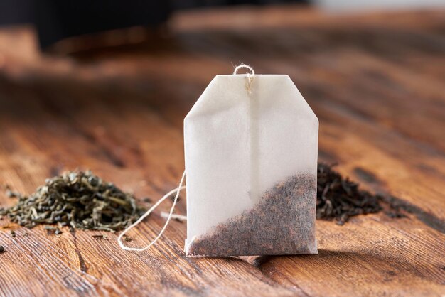 Photo tea bag green and black tea on an old wooden table