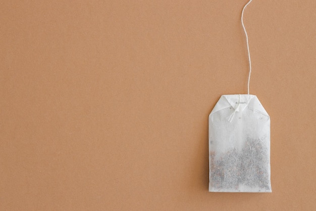 Tea bag with label on beige background space for text