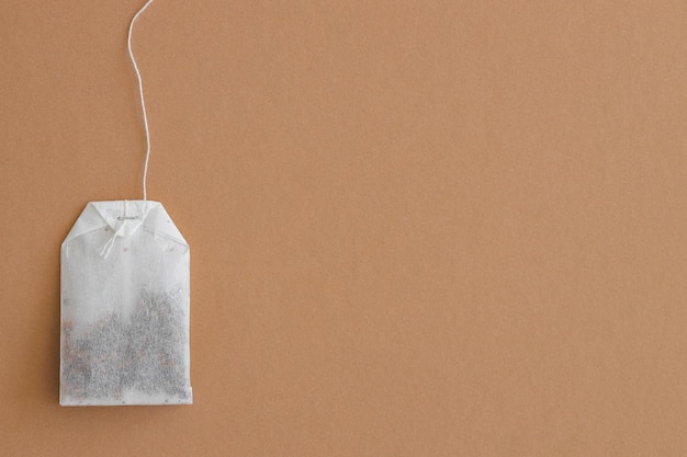 Tea bag with label on beige background space for text