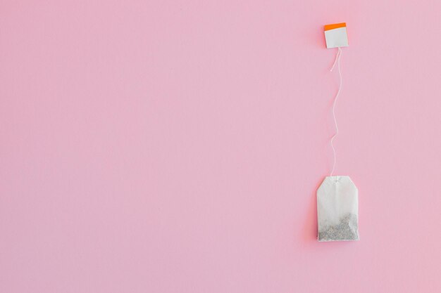 Tea bag with label on pink background space for text