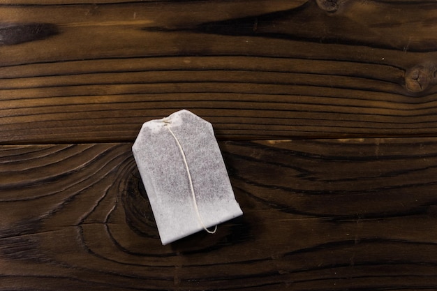 Tea bag on wooden table. Top view