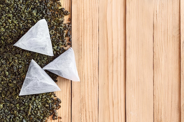 Foto tè in bustine sulle foglie secche di tè