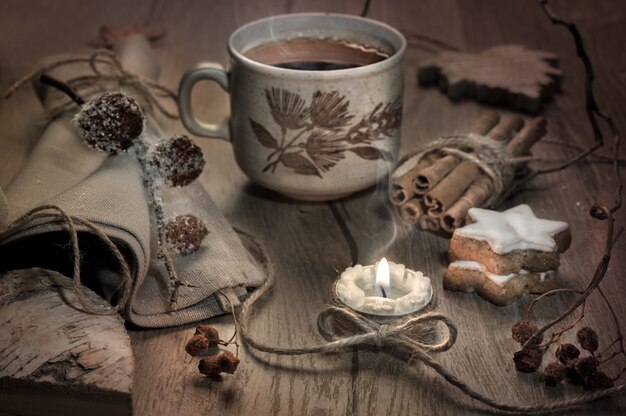 Tea, candle and Christmas cookies on decorated table, toned image