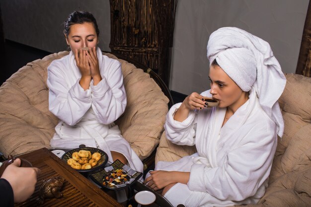 Tea ceremony after the sauna. Girls in white coats drink Chinese tea