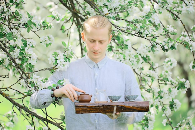 tea ceremony, Asian tea master prepares fresh spring green tea in the garden