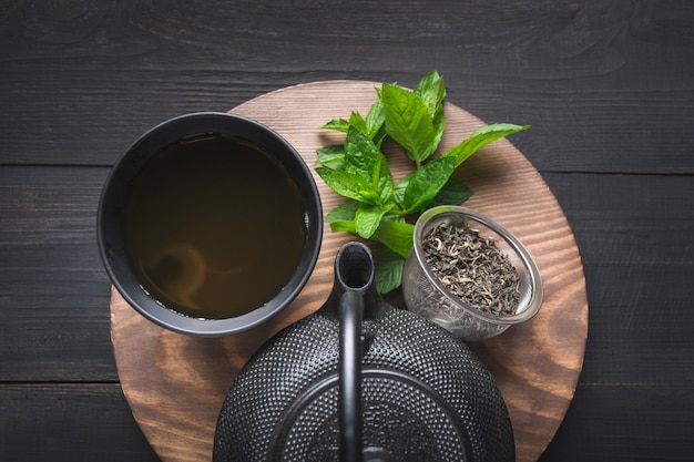 茶道。メリッサと暗い背景にやかんとお茶のカップ。中国茶のコンセプト。上からの眺め。