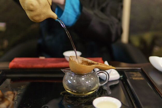 写真 茶道。マスターはふるいを通してお茶を注ぎます、スローモーション