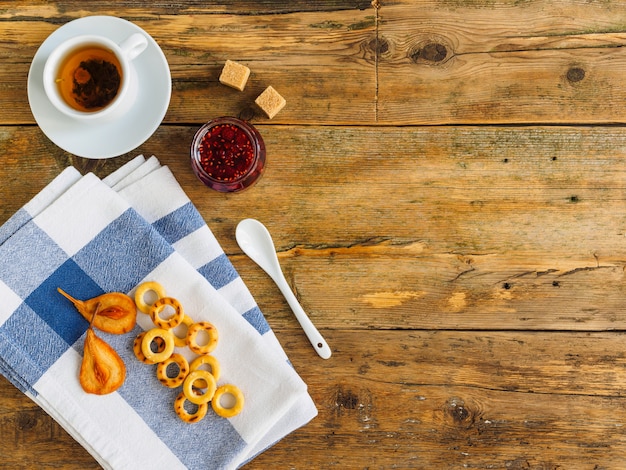 Tea ceremony on a wooden table. Jam and blue towel.